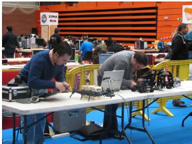 Foto de Ricardo y Alejandro en la mesa con la Granja de  Robots.